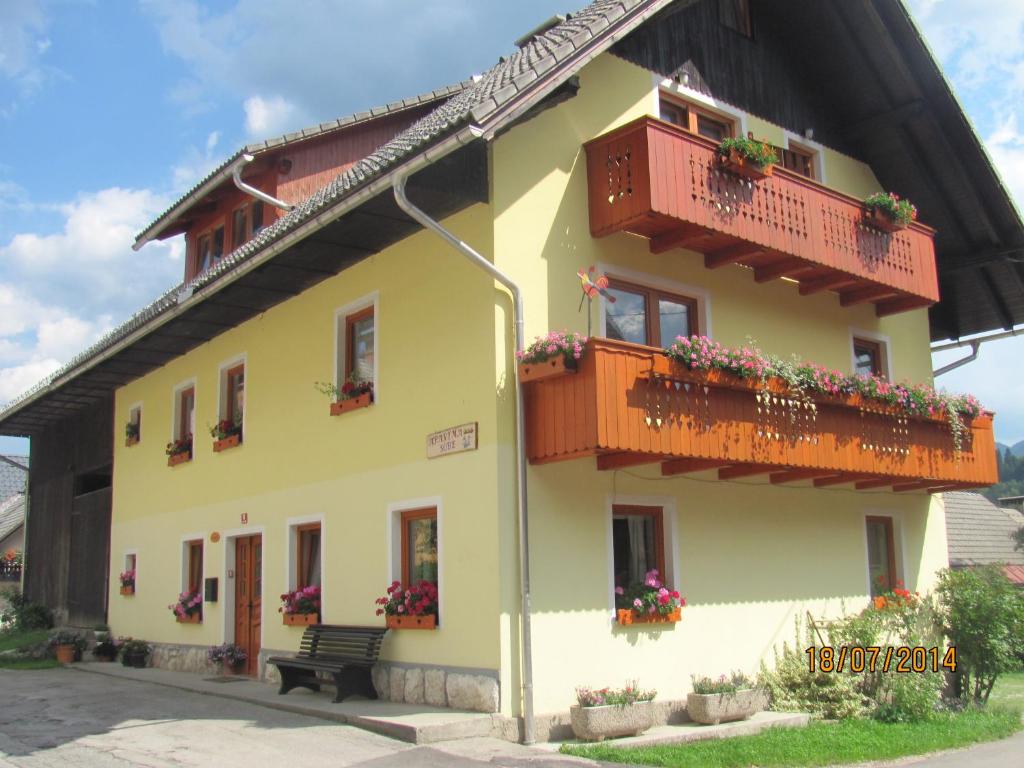 博希尼Apartments and Rooms Hodnik Slavko的一座黄色的建筑,设有阳台,鲜花盛开