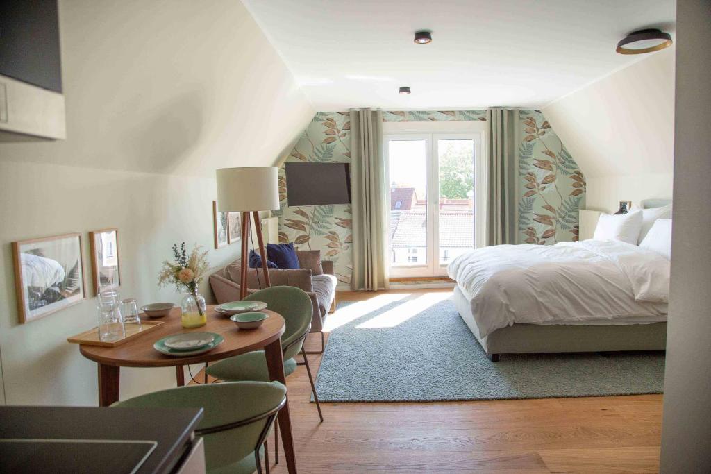 因戈尔施塔特21rooms的卧室配有一张床和一张桌子及椅子