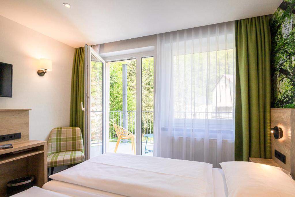 巴特尚道Hotel garni Grundmühle的酒店客房设有一张床和一个阳台。