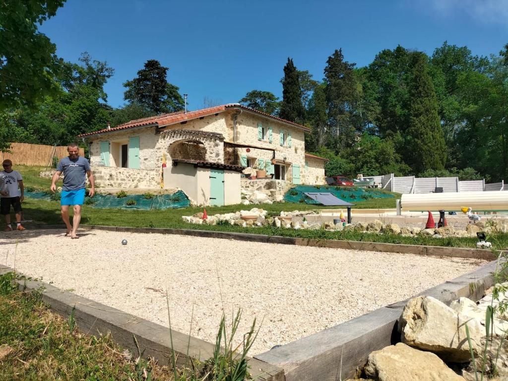 Montaut-les-CrénauxGîte Le Malartic Gersois avec piscine的一个人站在房子前面