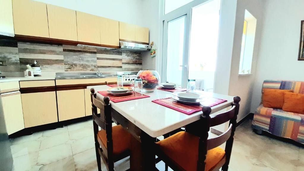 切萨雷奥港Zuccaro Apartment的厨房配有桌子、两把椅子和台面