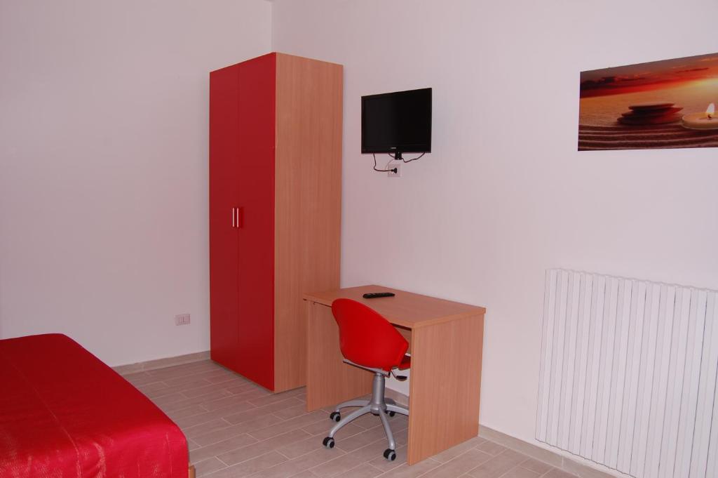 特拉尼B&B Fenix的一间卧室配有书桌、一张床和一个红色橱柜