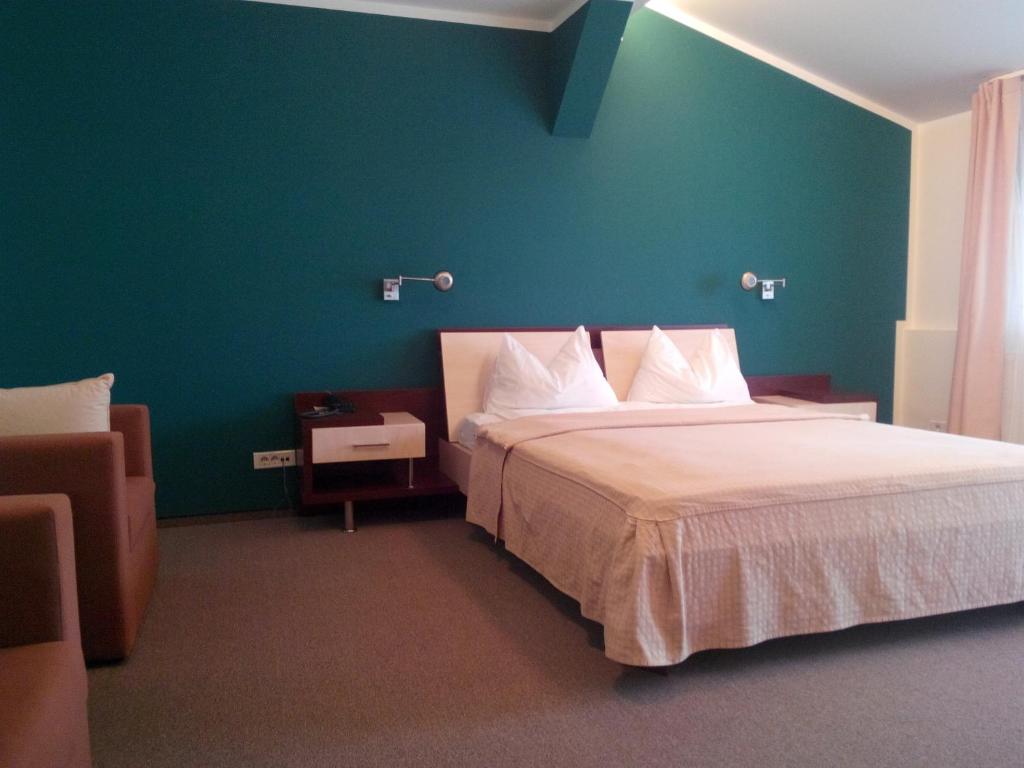 布加勒斯特巴尼萨公园酒店的一间卧室设有一张大床和绿色的墙壁