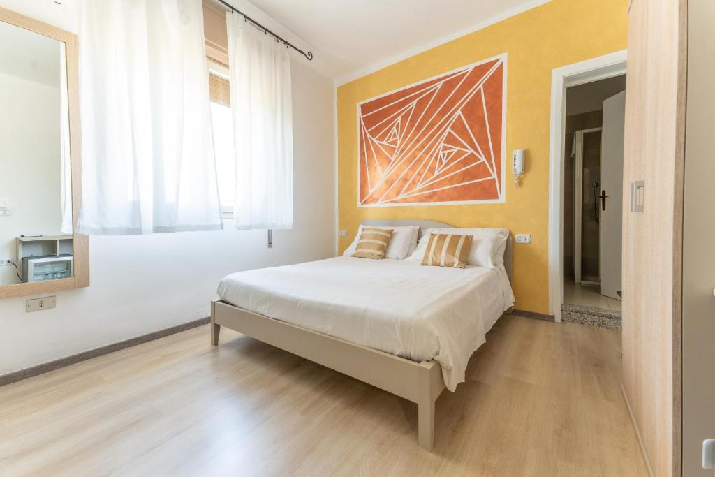佩斯基耶拉德加达Hotel Benaco ANTIGONEA的卧室配有一张床,墙上挂有绘画作品