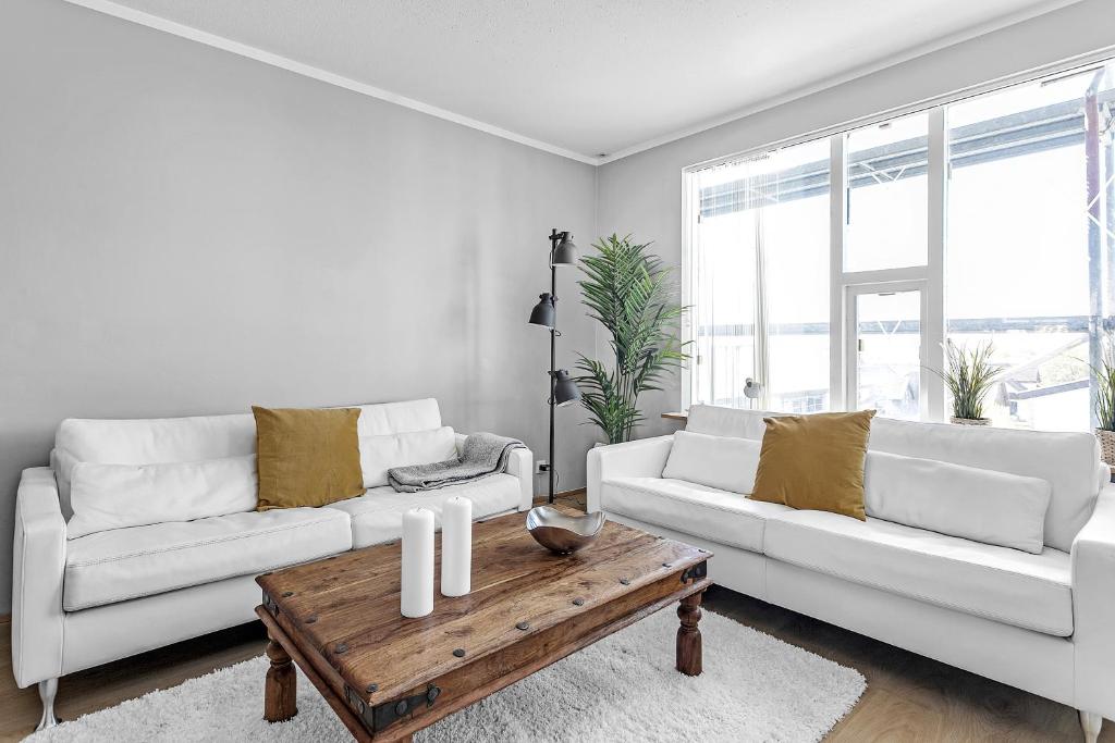 雷克雅未克Charming, 2 Bedroom Seaside Apartment的客厅配有2张白色沙发和木制咖啡桌