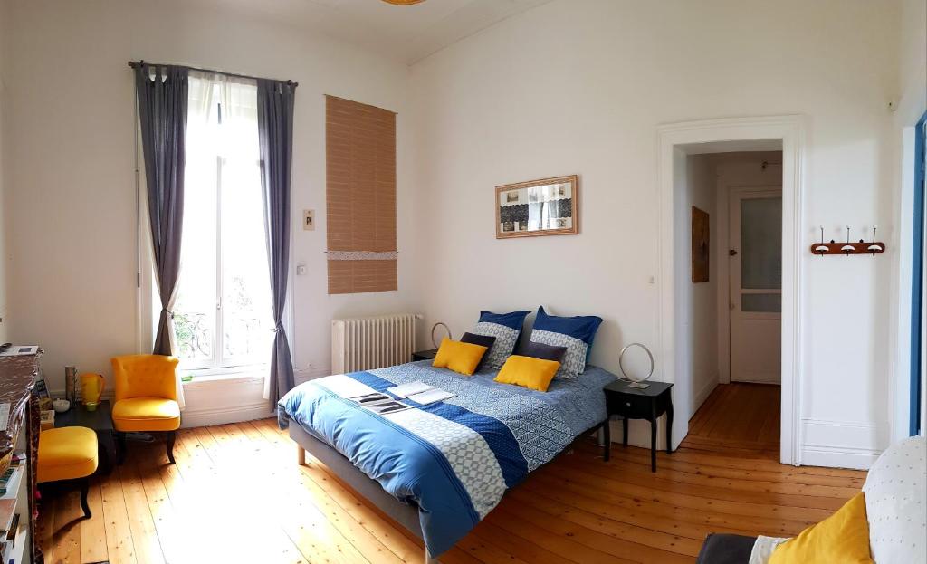 加来La maison des dentelliers的一间卧室配有蓝色和黄色枕头的床