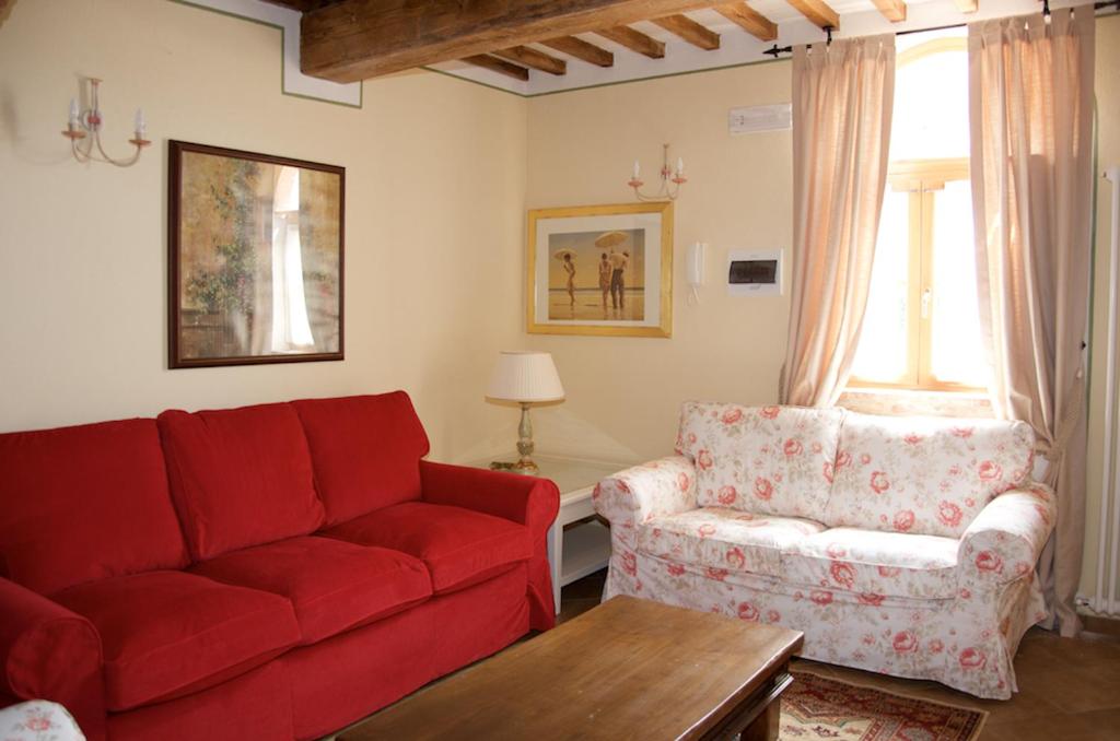 蒙特普齐亚诺Borgo 7 TigliAppartamento a Montepulciano n4的客厅配有红色的沙发和椅子