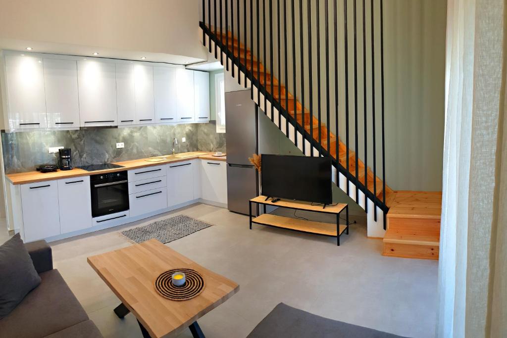 希俄斯Almeta Suites的一间厨房,配有白色橱柜和一台电视机