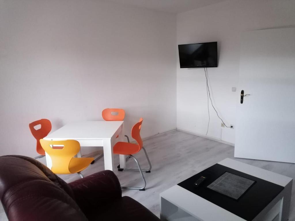 阿尔滕堡Kunstgasse 11 Wohnung 8的客厅配有白色桌子和橙色椅子