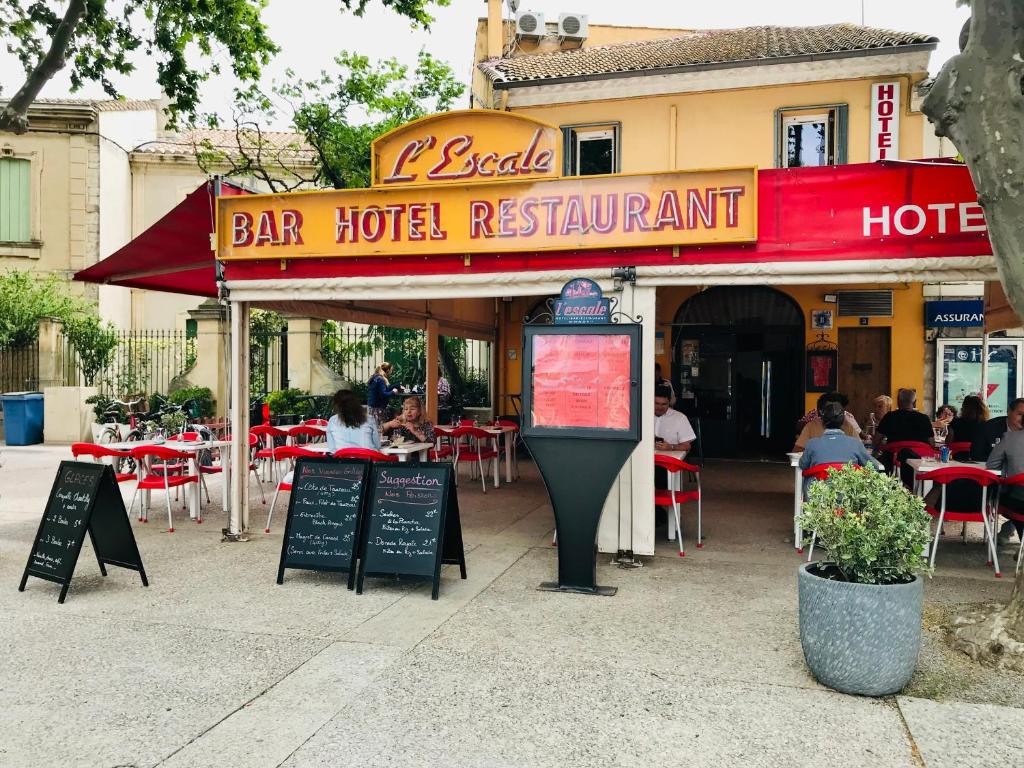艾格-莫尔特Hotel L'Escale的一间设有桌椅的酒吧餐厅以及一个停车计程表