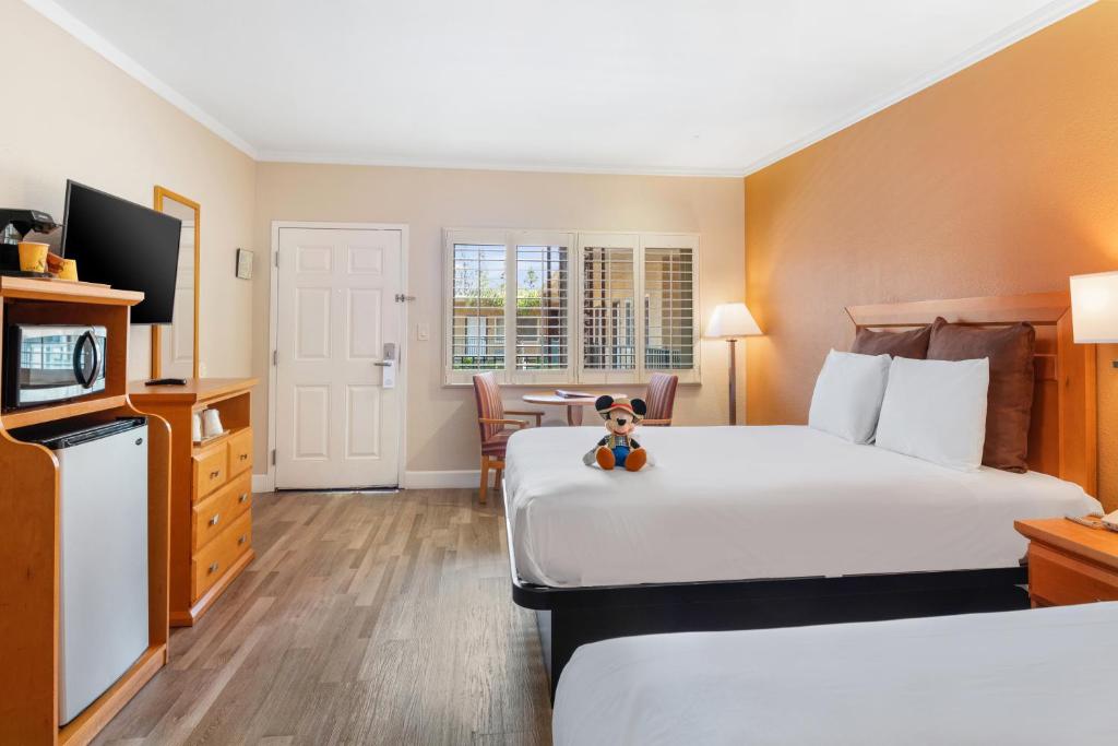 安纳海姆安纳海姆艾兰德套房汽车旅馆的酒店客房设有两张床,床上有泰迪熊
