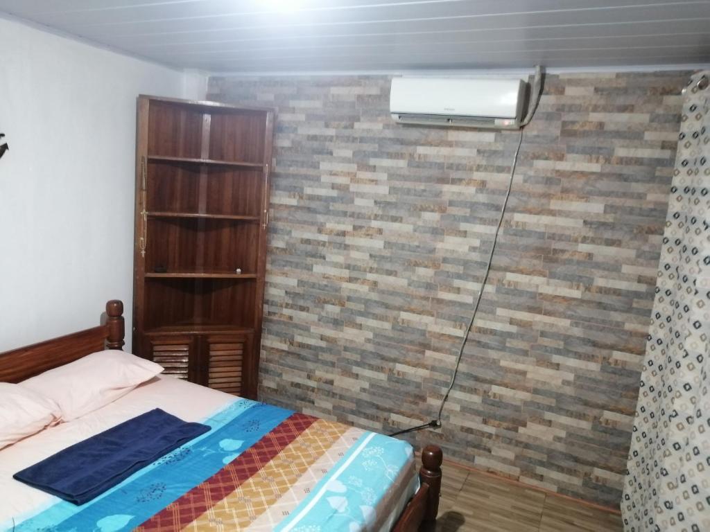 莱蒂西亚APARTA-Refugio El Retiro Verde的一间卧室配有一张床,砖墙上配有加热器