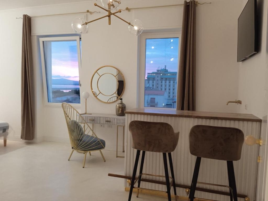 阿尔盖罗Casa Allegri的厨房配有两把椅子、一张桌子和一面镜子