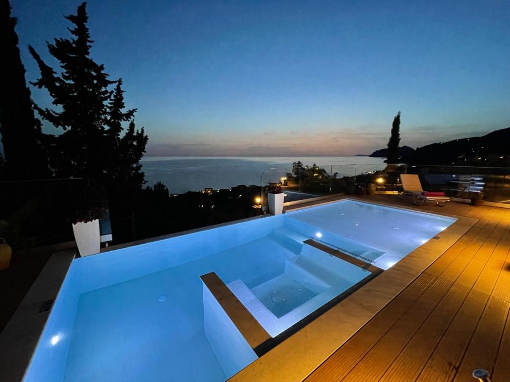 阿齐欧斯·贡多斯Casa Tramonto Beach View Agios Gordios Corfu的夜间甲板上的蓝色游泳池