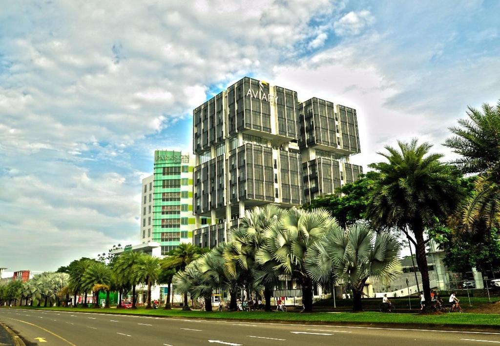 塞尔蓬阿维亚瑞宾泰罗酒店的一条街道前方有棕榈树的高楼