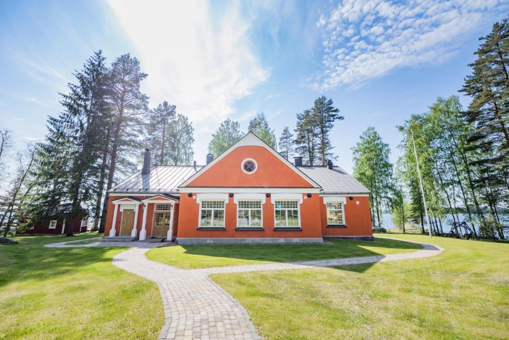 萨翁林纳B&B Taipaleenniemi的一座橙色的房子,有一条通往房子的路径
