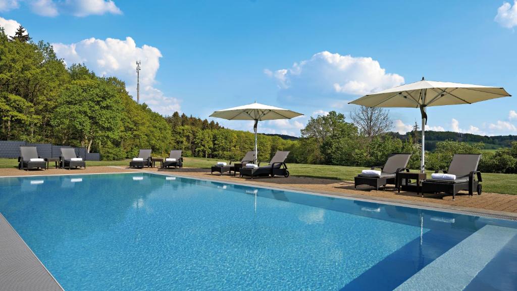 奥尔珀Hotel Diehlberg的一个带椅子和遮阳伞的游泳池