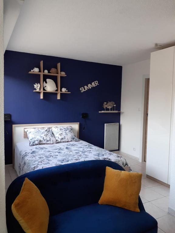 邦多勒L'Escale Marine : Centre ville/ Plage的一间卧室配有一张蓝色墙壁的床