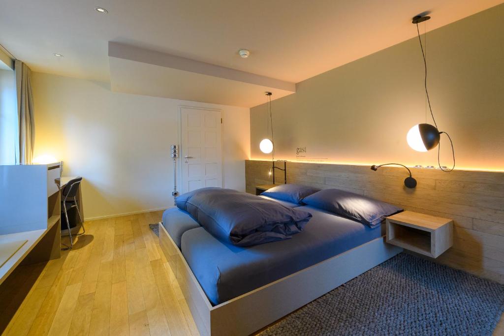 巴登林德费四利斯巴赫兰德酒店的一间卧室,卧室内配有一张蓝色大床