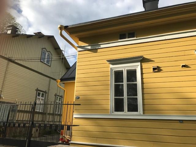 图尔库Old Turku Family Apartment的一座黄色的建筑,房子旁边设有窗户