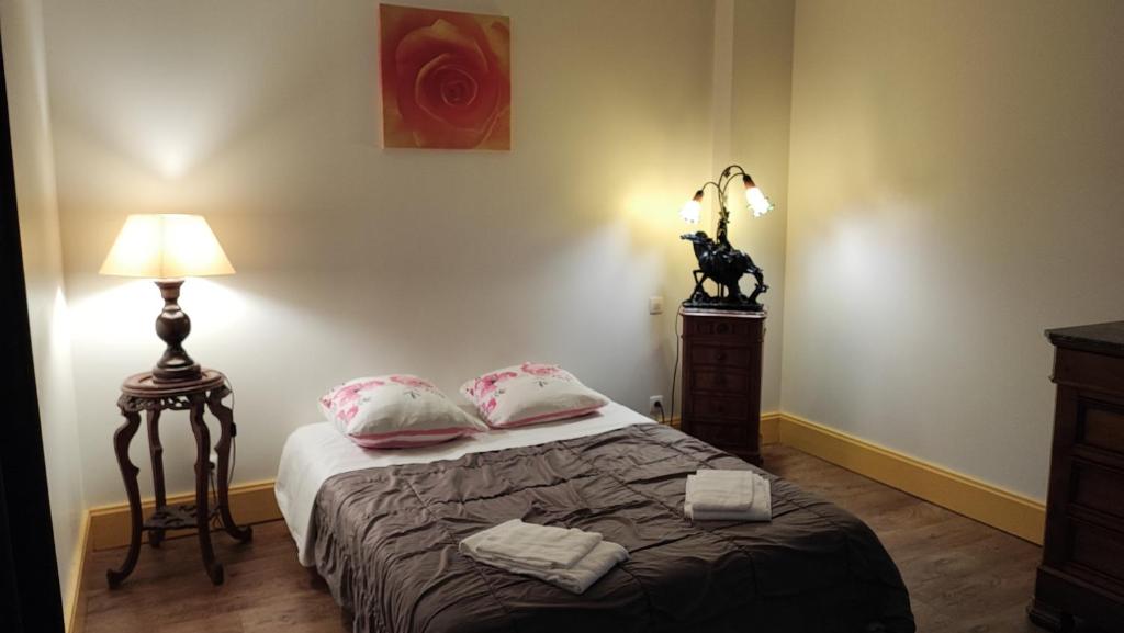 LormesGite Le Morvan的一间卧室配有带两个枕头和一盏灯的床