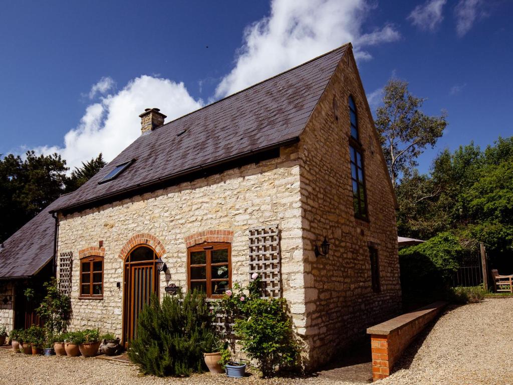 Little WitcombeJasmine Cottage的黑色屋顶的小砖砌建筑