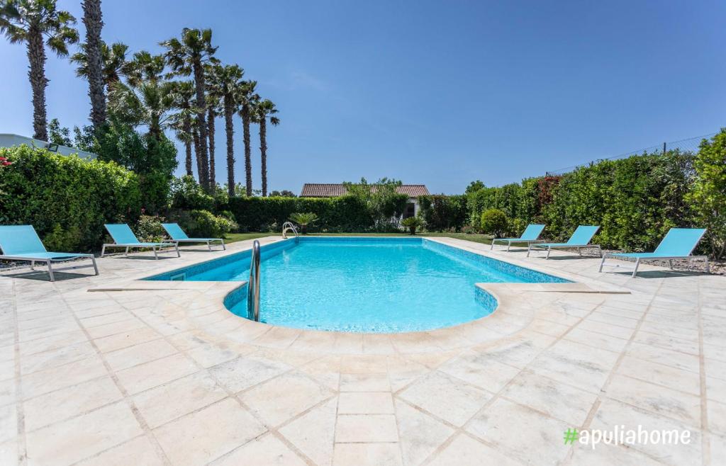 卡萨拉诺Villa Pompea al piano terra的一个带蓝色躺椅和树木的游泳池