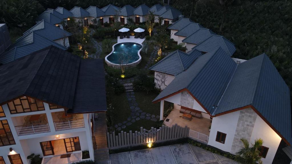 SidomuktiArtha Cottages的享有带游泳池的房屋的空中景致