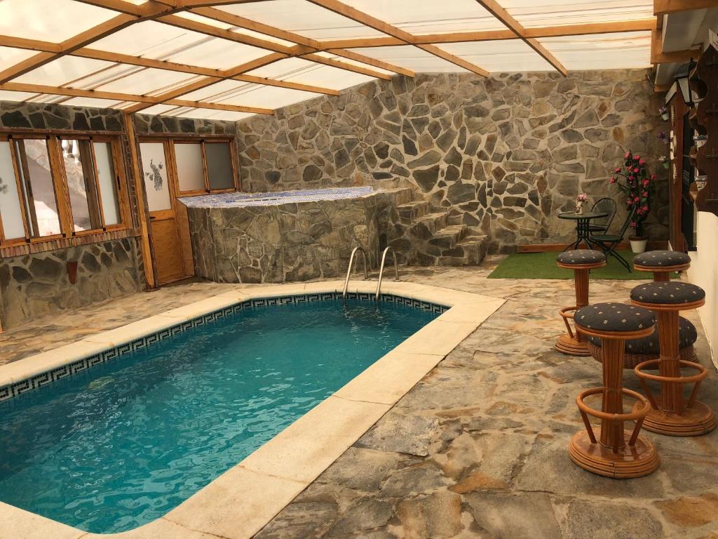 马拉加Casa rural Cristina- Piscina climatizada的一座带石墙的游泳池