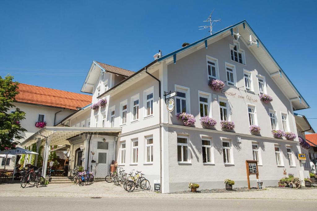 Görisried泽姆赫希酒店的一座白色的建筑,外面有自行车停放
