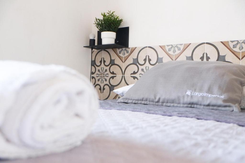 阿韦特拉纳Largo Imperiali B&B的卧室配有白色床,墙上挂着植物