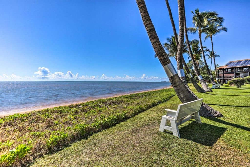 考纳卡凯Molokai Island Loft Lanai, Pool and Walk to Beach!的海滩旁的草地上摆放着白色的椅子