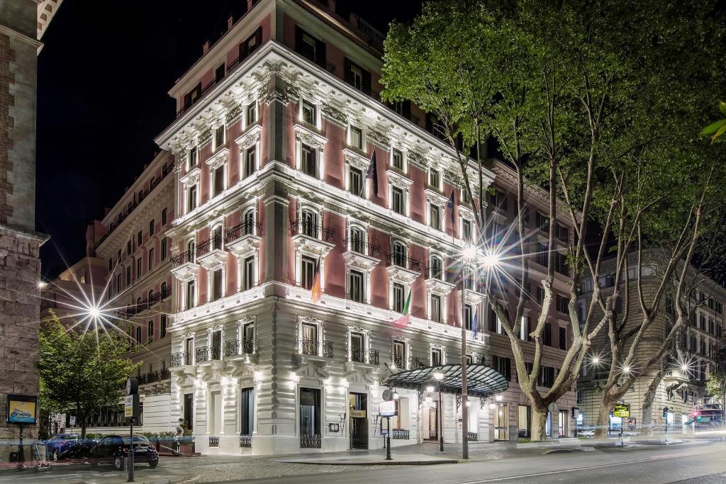 罗马巴廖尼女王饭店 –立鼎世酒店集团的夜幕降临的城市街道上一座高楼