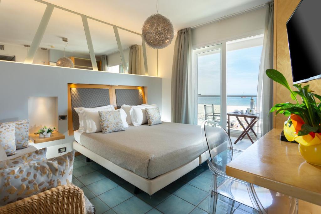 里米尼俱乐部酒店的一间卧室设有一张床,享有海景