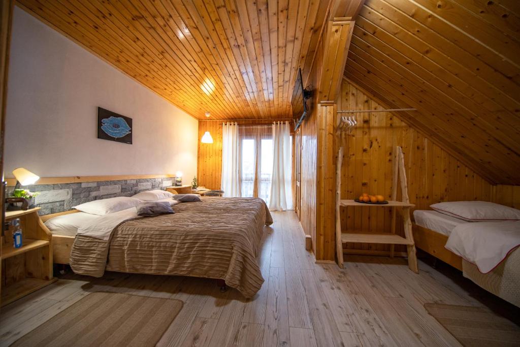 波亚纳布拉索夫Poiana Cristian的一间卧室设有两张床和木制天花板