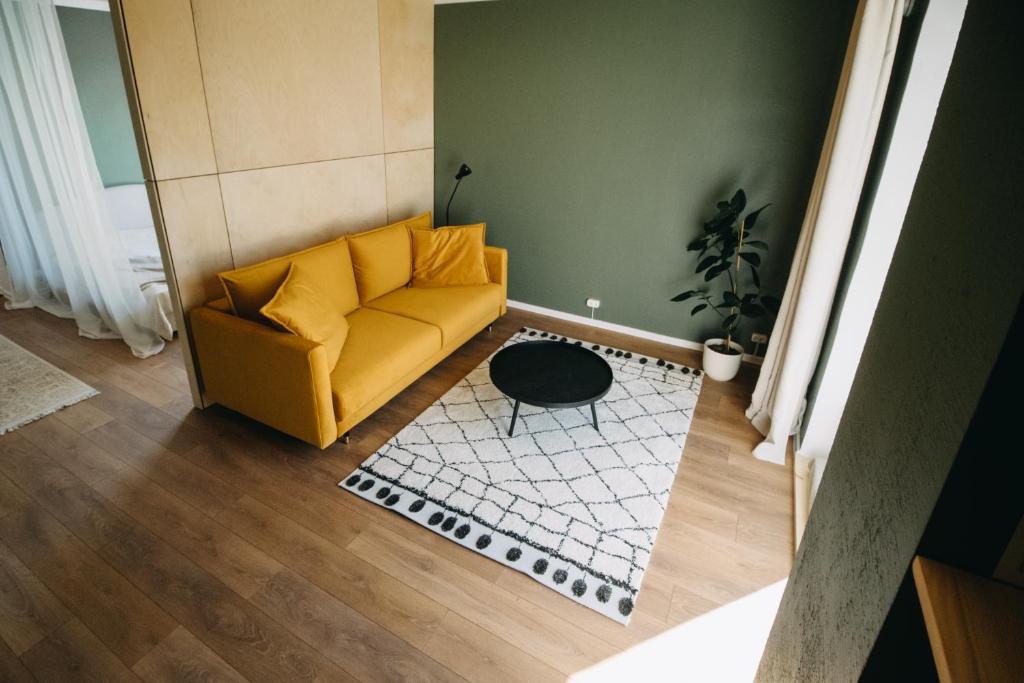 维尔扬迪Hubane korter Viljandi vanalinnas的客厅配有黄色沙发和地毯。