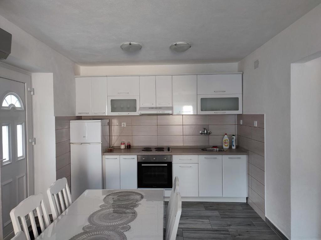 帕里斯特Apartment Rosić的一间厨房,配有白色家电和桌椅