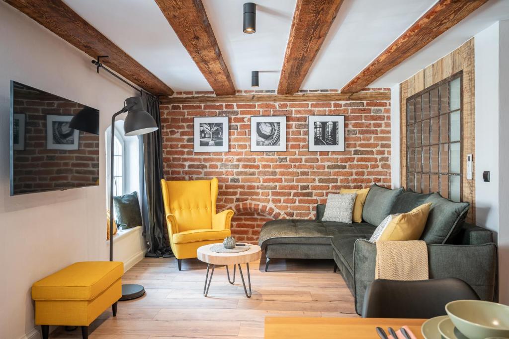 托伦Apartamenty Stare Cegły的带沙发和砖墙的客厅