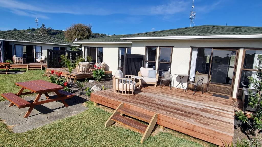 纳尔逊Tāhuna Beach Holiday Park的后院设有带桌子和长凳的木甲板