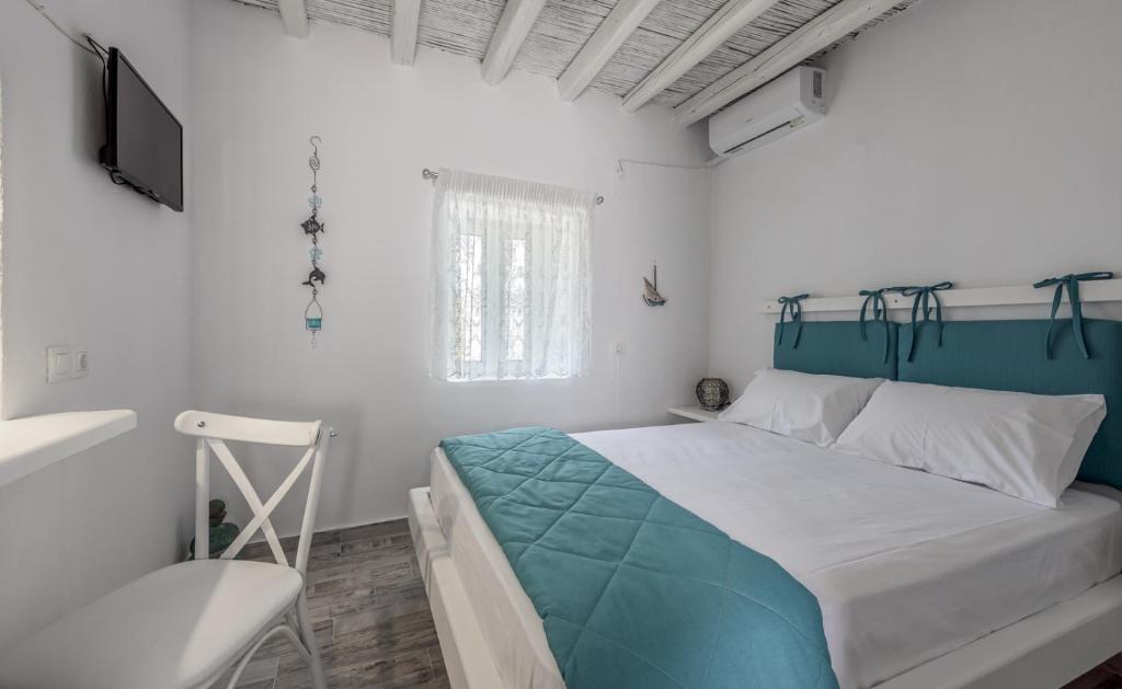 MytakasSanta Marina Milos的一间卧室配有一张床、一台电视和一把椅子