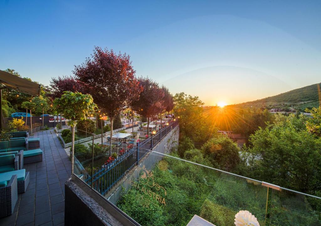 普里什蒂纳Magra Austria Hotel & Restaurant Prishtine的享有日落景观的阳台