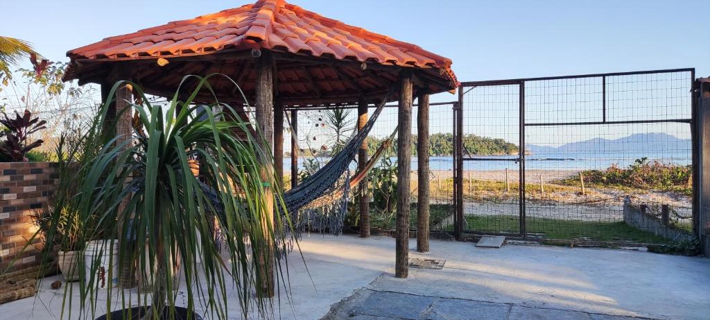 安格拉杜斯雷斯Flat com portão na Praia的海滩前带吊床的凉亭