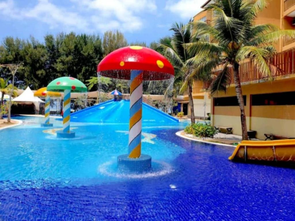 万津ccfd 5pax Gold Coast Morib Resort - Banting Sepang KLIA Tanjung Sepat的红色蘑菇度假村的游泳池
