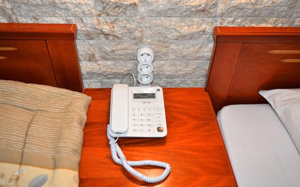 帕拉利亚卡泰里尼斯VILLA Vasilios EXARHOS的一张桌子上床边的电话