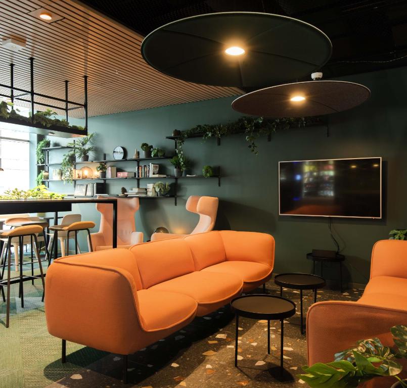 卑尔根Citybox Bergen Danmarksplass的一间带橙色沙发的客厅和一间酒吧