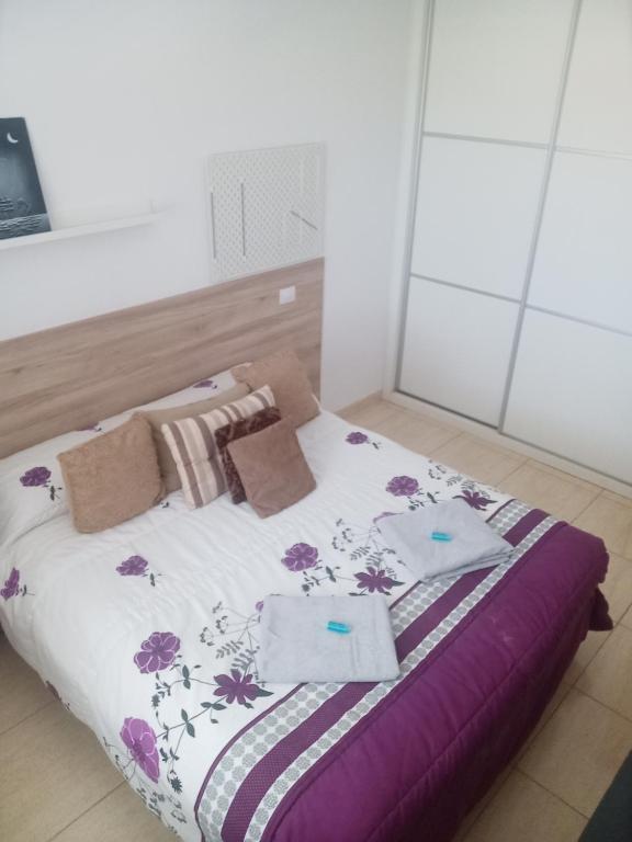 维辛达里奥Habitación Privada May的一间卧室配有一张紫色和紫色床单的床