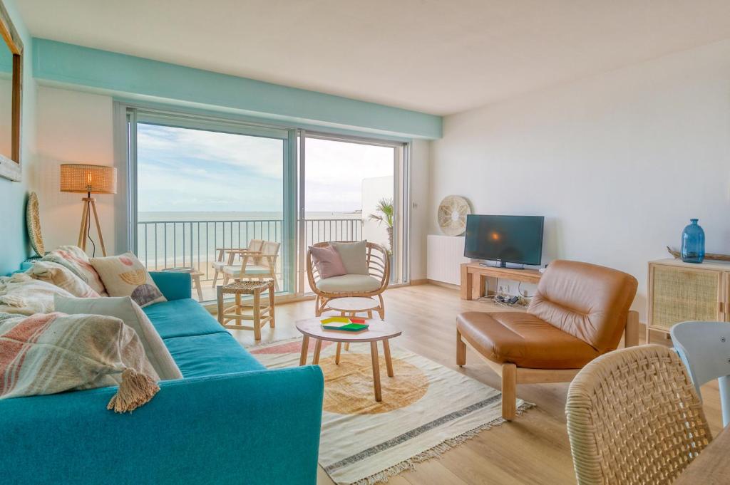 拉波勒Vue sur mer La Baule Hydra的客厅配有蓝色的沙发和电视