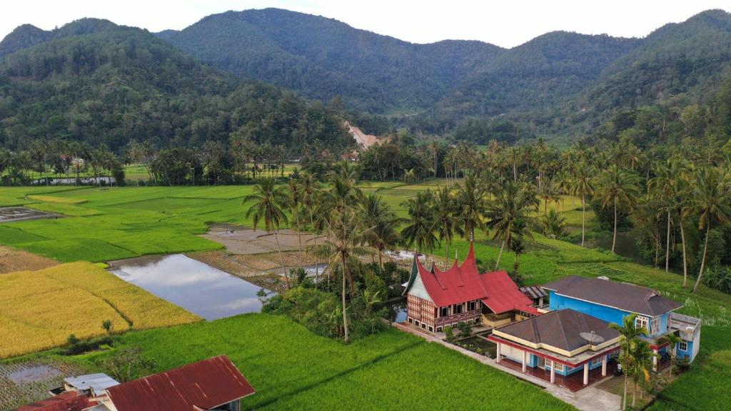 BasoRumah Gadang Simarasok的享有高山房屋的空中景致