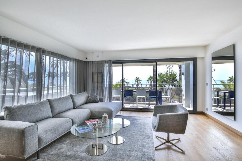 尼斯Sublime Appartement Promenade des Anglais (2)的带沙发和玻璃桌的客厅