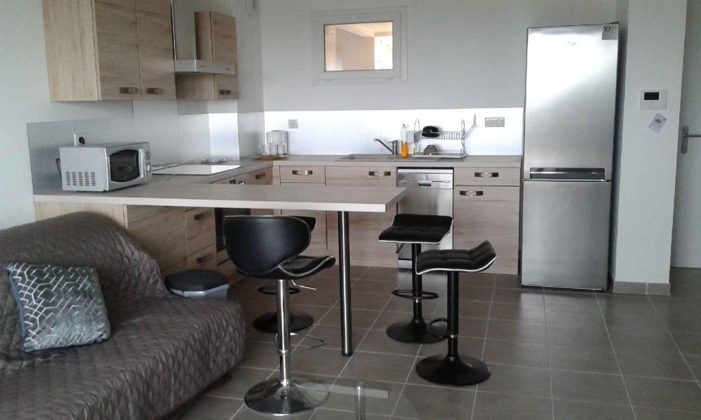 阿雅克修Bella Vista 2A的厨房配有沙发和带凳子的台面
